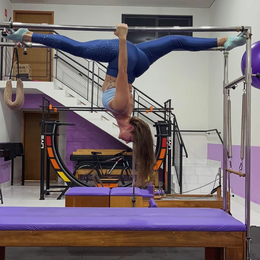 Renata Ramos praticando um exercício avançado em equipamento de Pilates